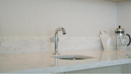 This polished chrome kitchen faucet has a sleek, reflective finish ideal for modern kitchens.