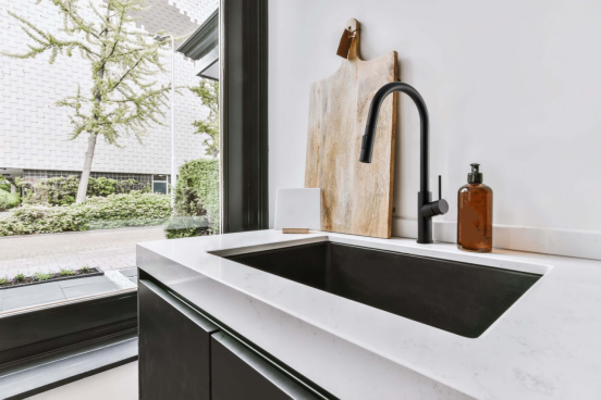 This wall-mount kitchen faucet creates the floating illusion, elevating the modern minimalist design of this kitchen.