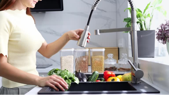 The kitchen faucet’s pull-down pause button stops water instantly, streamlining kitchen tasks.